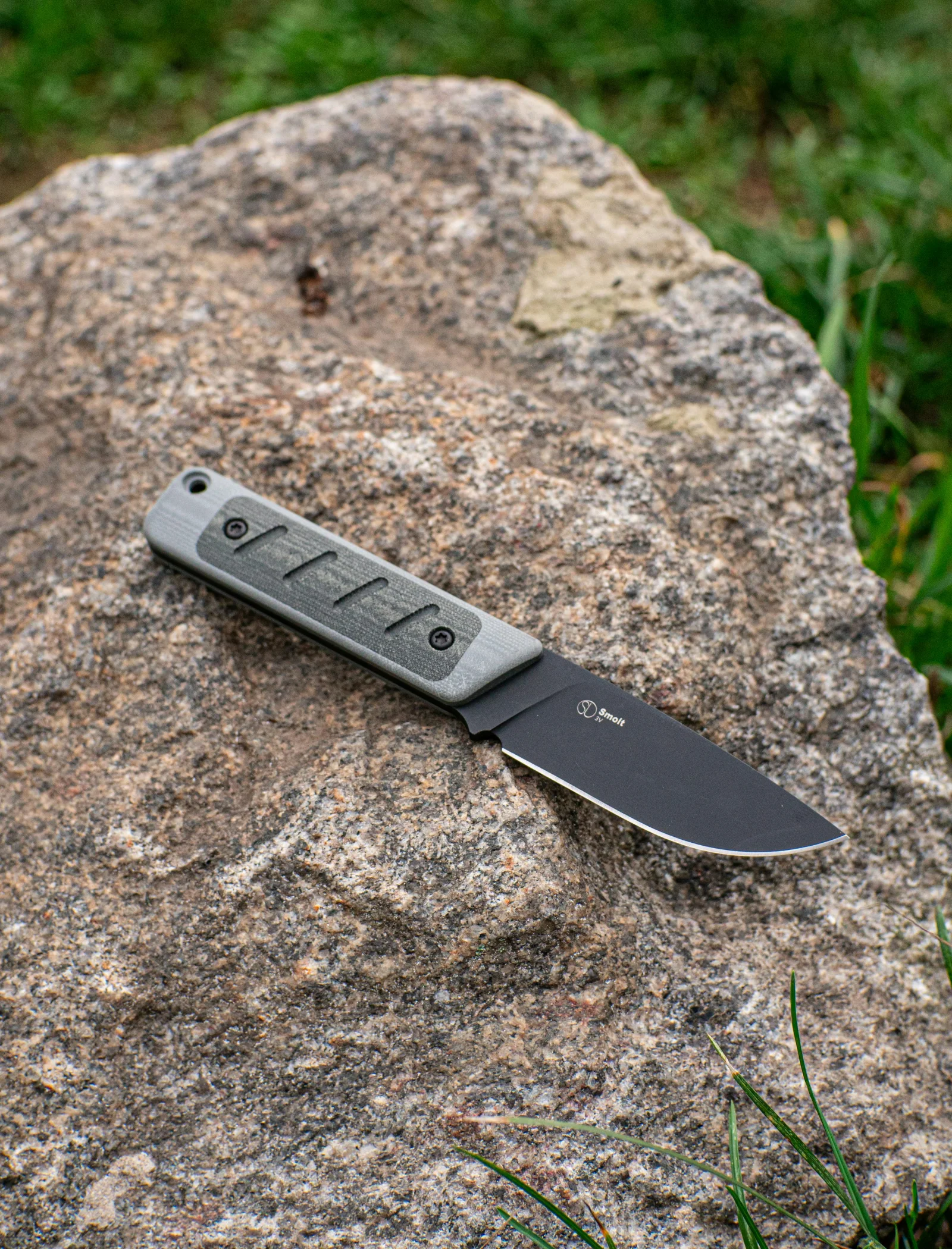 An outdoor knife on a textured rock